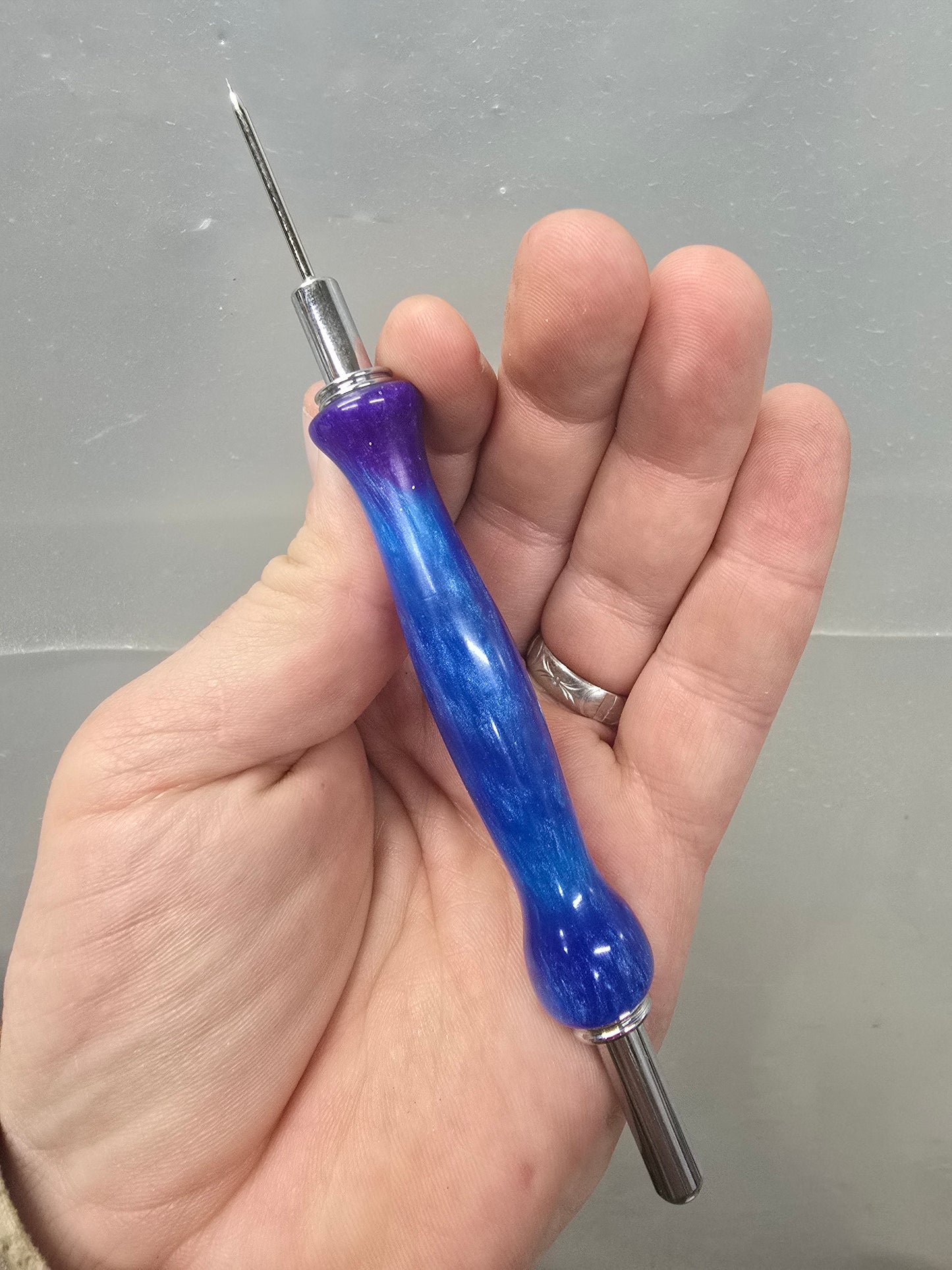 Blue and purple sewing seam ripper and stiletto combo tool